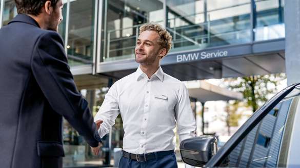 BMW Mitarbeiter begrüßt einen Kunden
